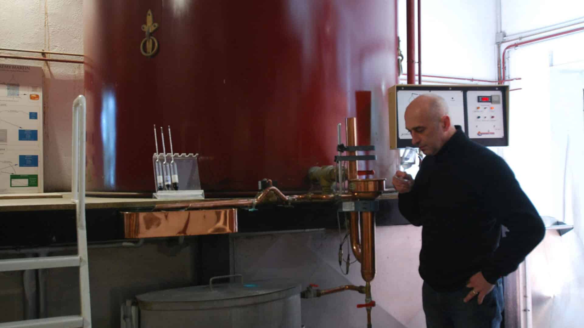 Distiller tasting his cognac brandy during distillation