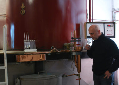 Distillateur dégustant son eau-de-vie de cognac pendant la distillation
